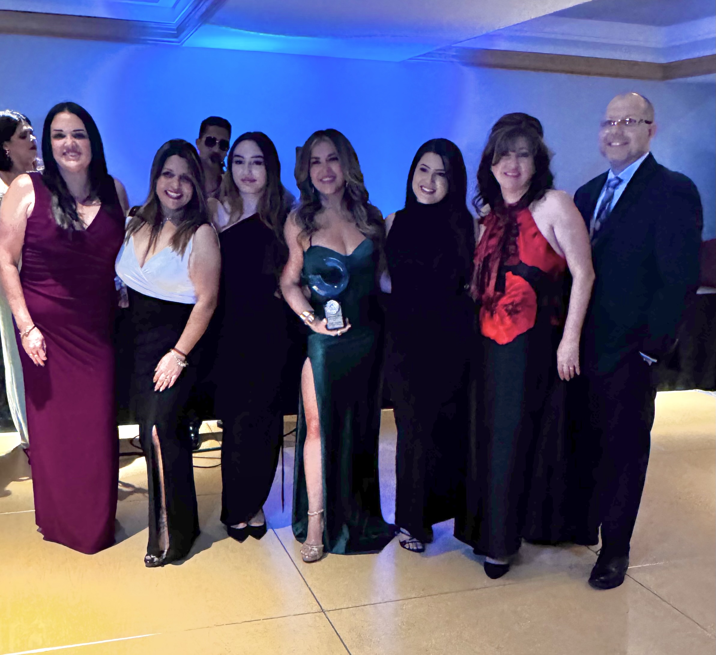 Daysi holding her award with event guests